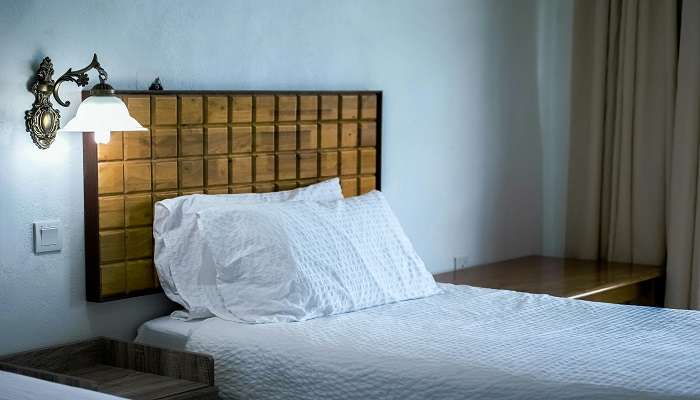 A bed with a headboard in the room at one of the best Hotels In Perungalathur. 