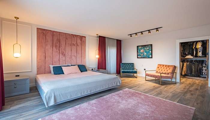 A twin bed in a hotel with blue and white pillows on the bed at the best hotels in Indiranagar.