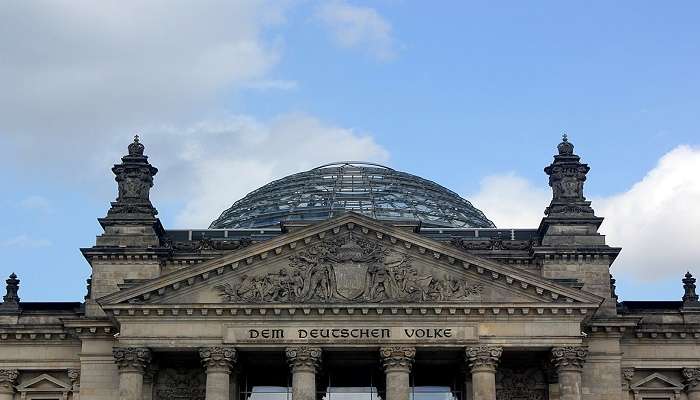 Reichstag Building in Berlin with a clear view of its grand architecture under a cloudy sky