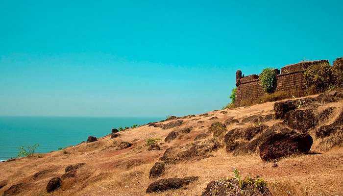 Bird's eye view of Chapora Fort's stone walls and ramparts overlooking the coastline and verdant Goan landscape.