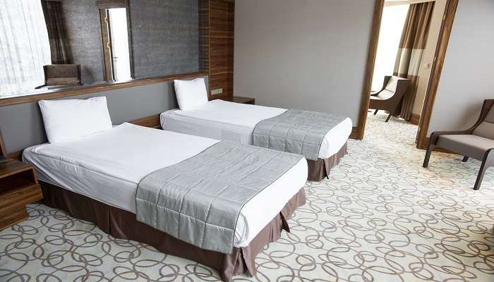 Twin beds in a room in a hotel in Maduravoyal.