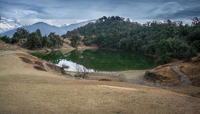 deorai tal covered in lush greenery and snow-capped mountains in the backgroud