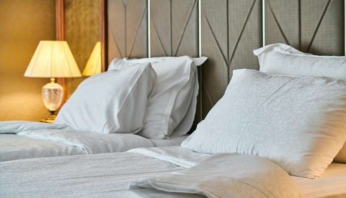 White linen on the bed of a hotel room,Hotels In Royapuram