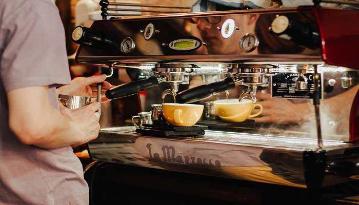 A person preparing the coffee at the best cafe in Rajajinagar.