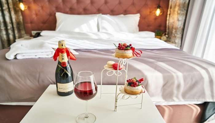 A wine bottle and glass on the table of a hotel room, Hotels In Royapuram