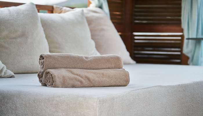 A bed with towels in a hotel room in Maduravoyal.