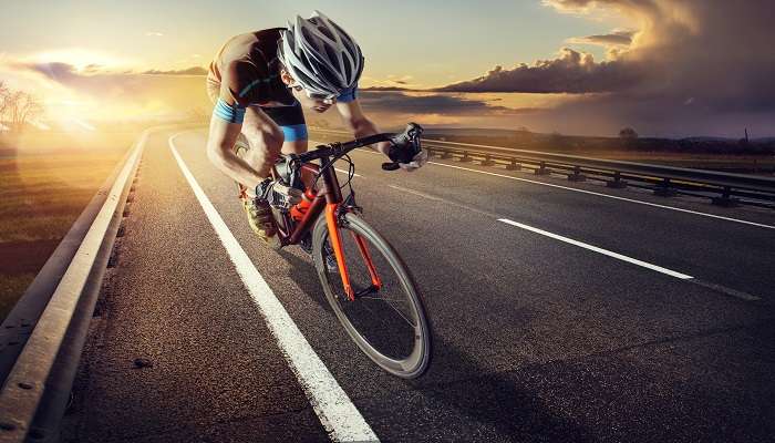  The cyclist rides on his bike at sunset 