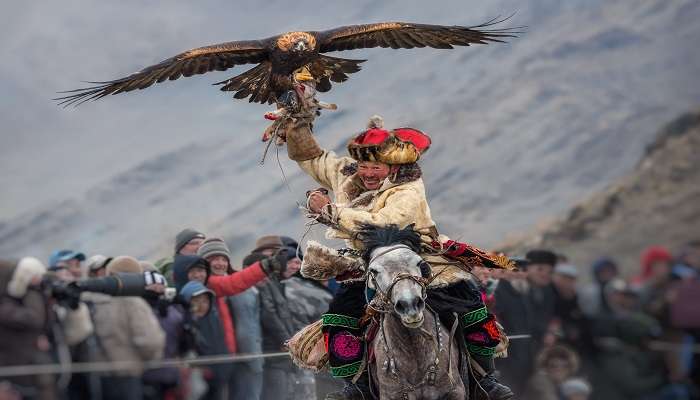 A Triumphant Mongolian Hunter In Riding On Horse during Golden Eagle Festival in Mongolia.