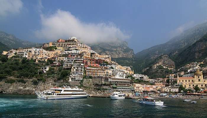 The view of the pyramid-shaped cliffside town of Positano from a boat near the Amalfi Coast Italy.