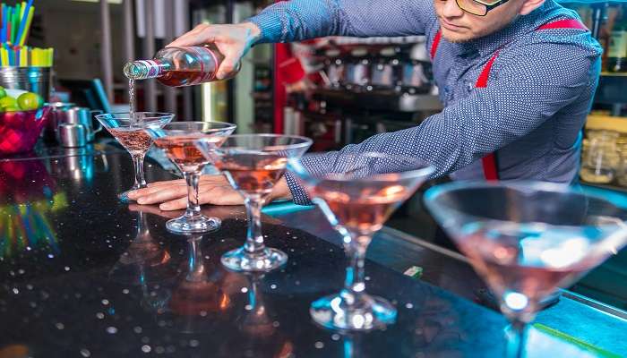 A staff pouring liquor in glasses, in one of the best Pubs in Pyrmont