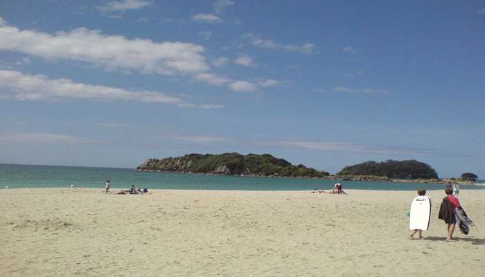 Visitors enjoying a relaxing day at the beach in Mount Maunganui. 