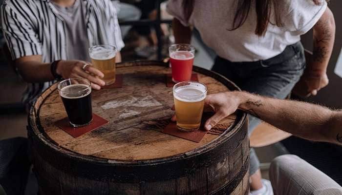 Three glasses of beer on a barrel-style table