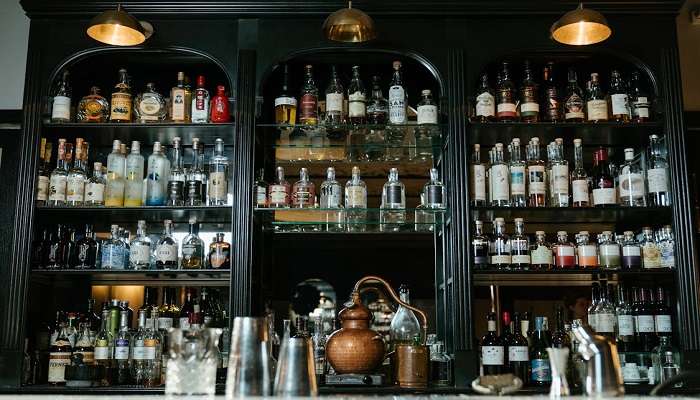 Clear Glass Bottles on Brown Wooden Shelf in a pub in Ulladulla. 