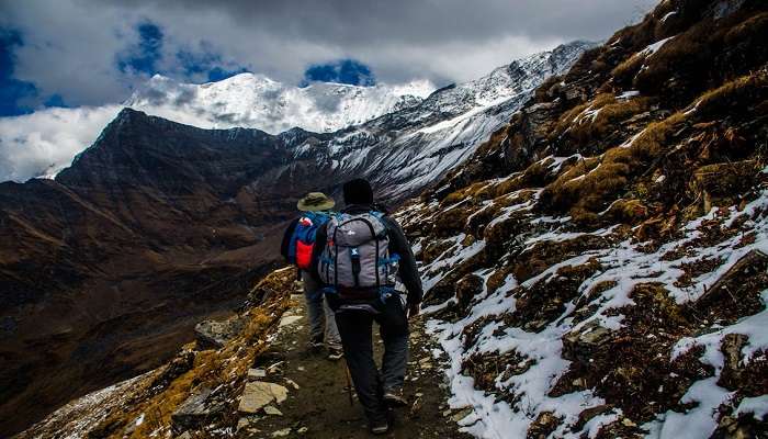 people trekking in the snow-covered trails in joshimath to visit in Tungnath in december.