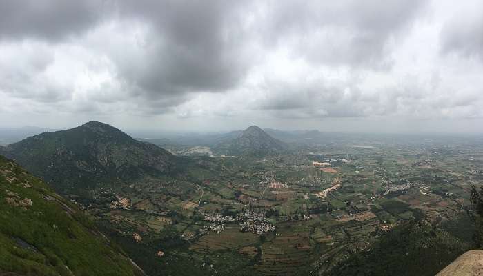 Sunrise at Nandi Hills, misty clouds, and greenery all around; this is a serene getaway from the frenzy of Devanahalli Fort. 