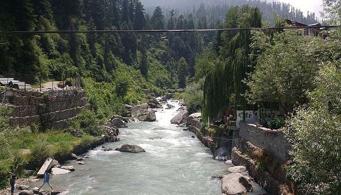 River Beas is flowing down near a village in Manali.