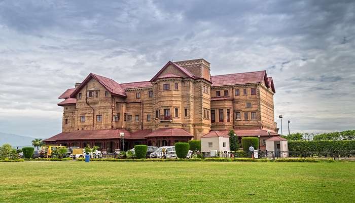 The majestic Amar Mahal Palace Museum front view with a green field in Jammu, India.