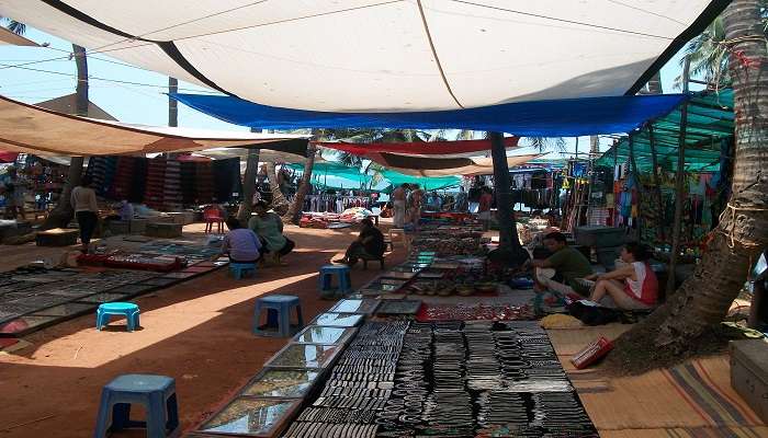 Colourful stalls and crowds at the vibrant Anjuna Flea Market near the Chapora River Cruise. 