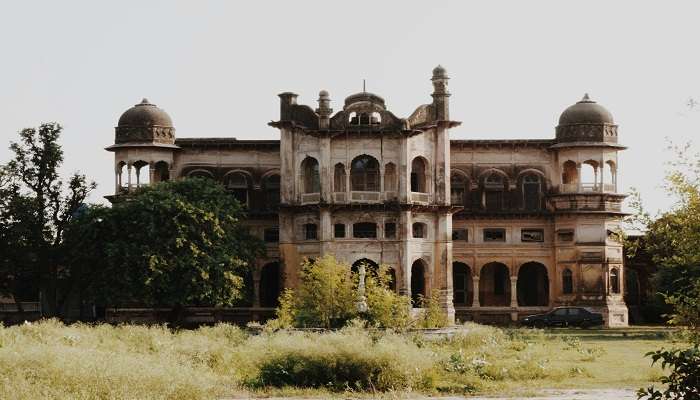 Tall tower of Chehni Kothi against the backdrop of Himalayan mountains