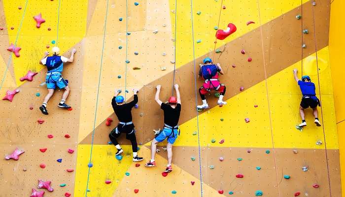 A group of climbers athletes compete in a high-speed ascent of a steep wall in Harbor Land 