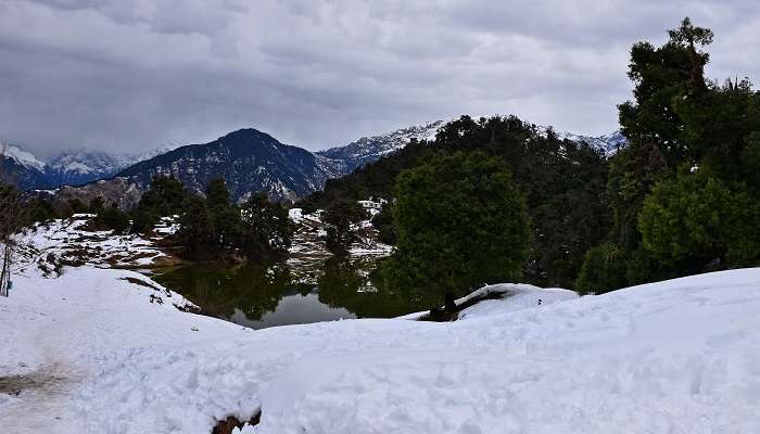 The Deoria lake, surrounded by snow covered landscapes and mountains 