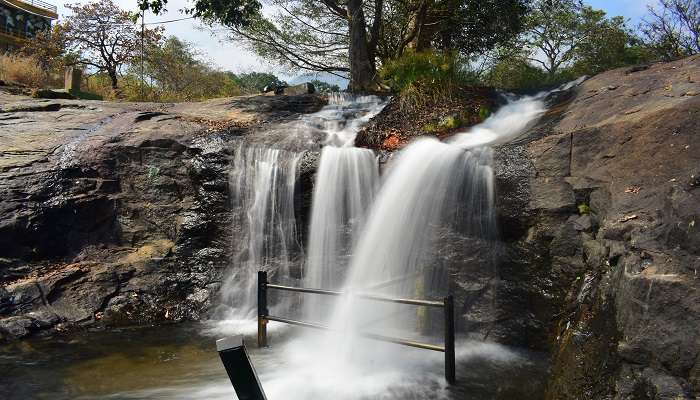 A view of the serene Kumbakkarai Falls amidst lush greenery