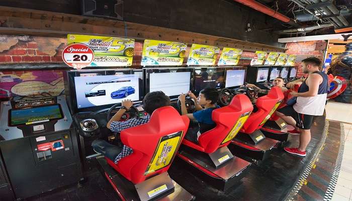 Teenagers and Kids happily play on game machines at the Motor city at Harbor Land. 