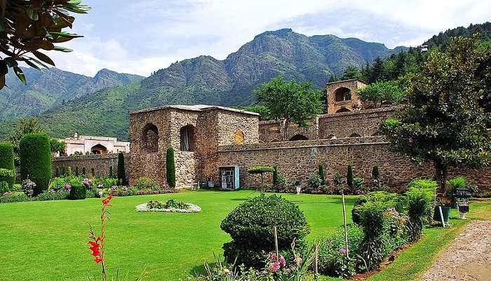 Lit-up terraced gardens of Pari Mahal during evening time, overlooking city lights of Srinagar and Dal Lake.