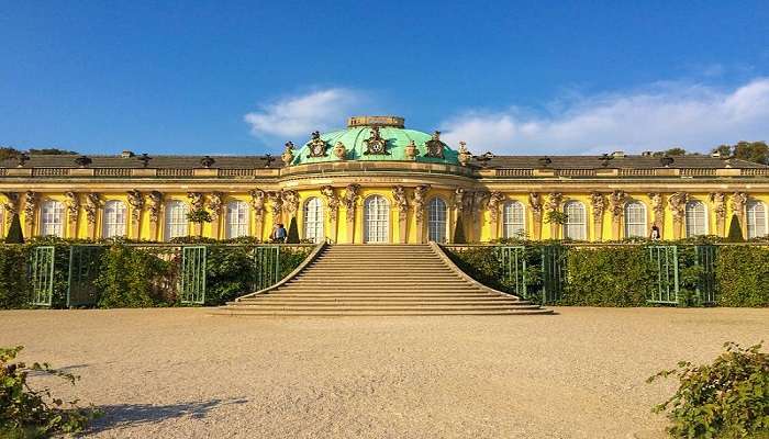 Explore Sanssouci palace with vineyard terraces and ornate interiors.