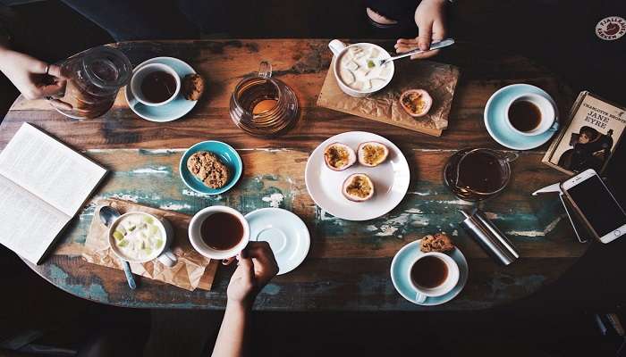 Bright and inviting interior of The Rafters featuring a variety of coffee options, cakes, and pastries, with customers dining at the best cafes in Palmerston.