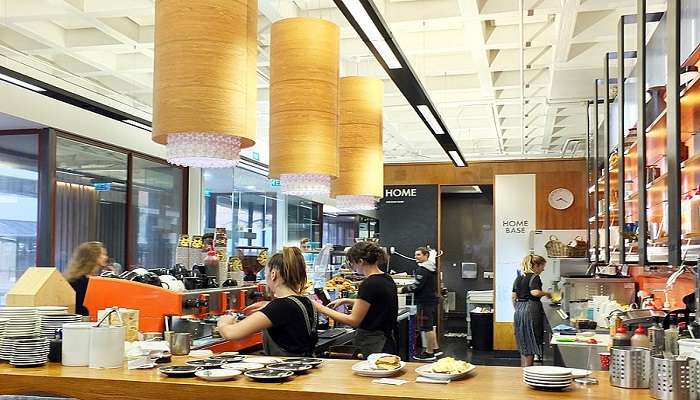 Interior of Cafe Royale showcasing a cosy ambiance with coffee blends displayed and patrons enjoying their drinks.