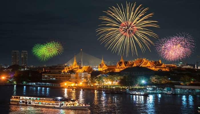 Grand palace and cruise ship at night with fireworks in Bangkok